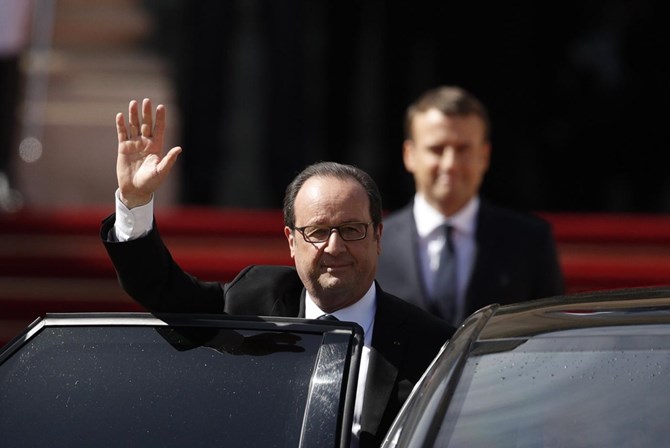 Hollande acena aos jornalistas enquanto deixa o Eliseu.