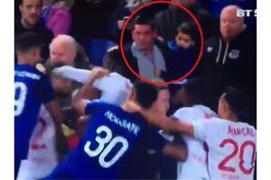 Everton fan holding a baby tries to fight Lyon players during Europa League match.mp4