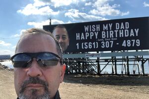 Filhos tramam pai com cartaz de parabéns com número de telefone
