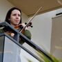 A rapariga em quarentena de violino à janela