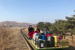 Diplomatas russos empurram vagão da bagagem no regresso da Coreia do Norte