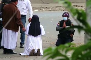 Freira ajoelha-se perante polícia para proteger manifestantes no Myanmar 