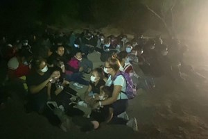 Famílias mexicanas atravessam fronteira EUA-México à noite