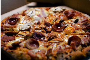 Dentro de uma fábrica, descobre-se a nobre arte das pizzas