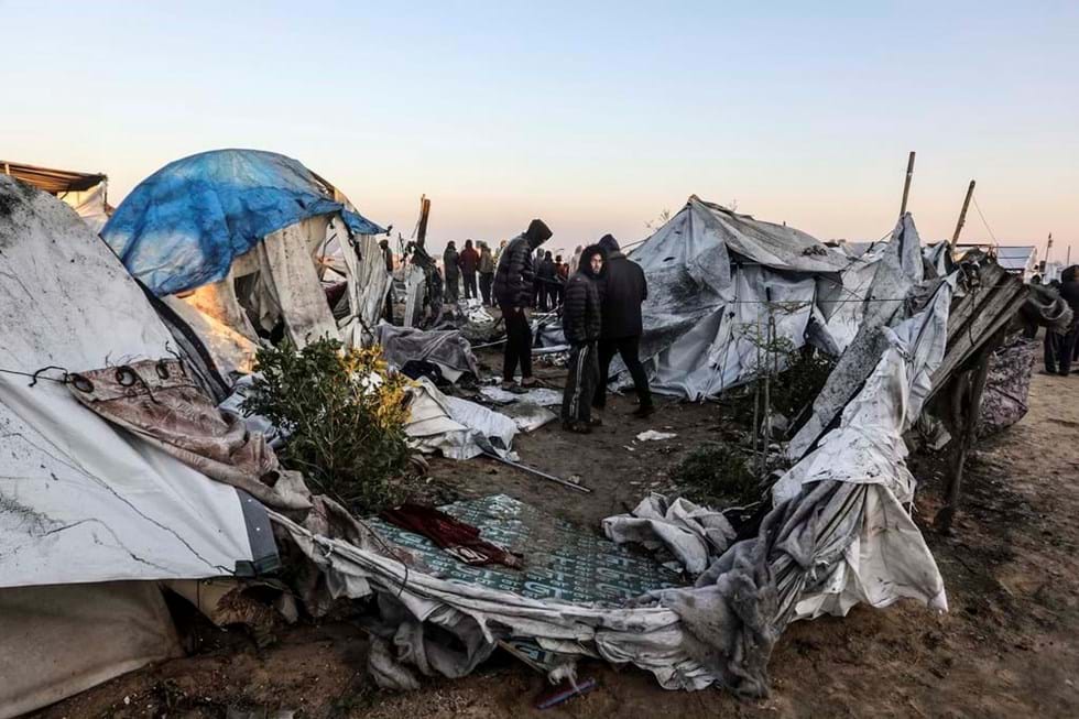 Os palestinos observam as consequências do ataque israelense ao campo de refugiados de Mawasi Khan Younis, que matou pelo menos 11 pessoas.