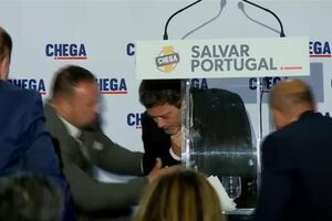 O momento em que André Ventura leva a mão ao peito e ao pescoço e cai inanimado no palco