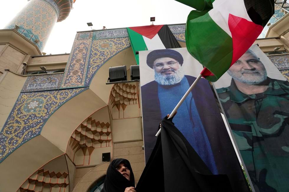 Um manifestante iraniano com a bandeira palestina foi morto por Israel em frente a um retrato do líder do ex -Hezbollah, Hassan Nosrallah, e o falecido General Qcashimani, o Corpo de Guarda Revolucionária Iraniana, foi morto em um ataque ao drone dos EUA.