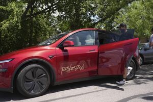 Tesla "Robotaxi" com passageiro a entrar no carro