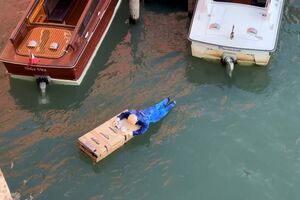 Manequim de Jeff Bezos agarrado a caixa da Amazon com notas nas mãos colocado no Grande Canal de Veneza