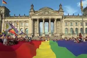 Bandeira arco-íris gigante estendida em frente ao parlamento alemão