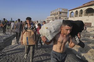 Homens carregam mantimentos em Gaza, no meio da crise humanitária e de bloqueios