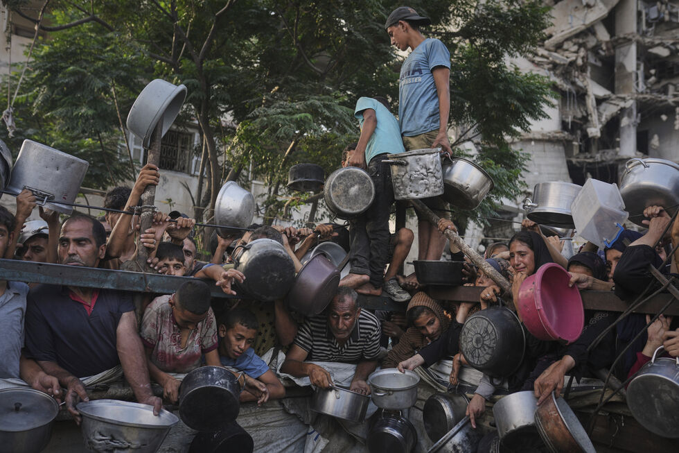 Pessoas usam panelas para obter ajuda em Gaza, localidade onde foi declarada fome