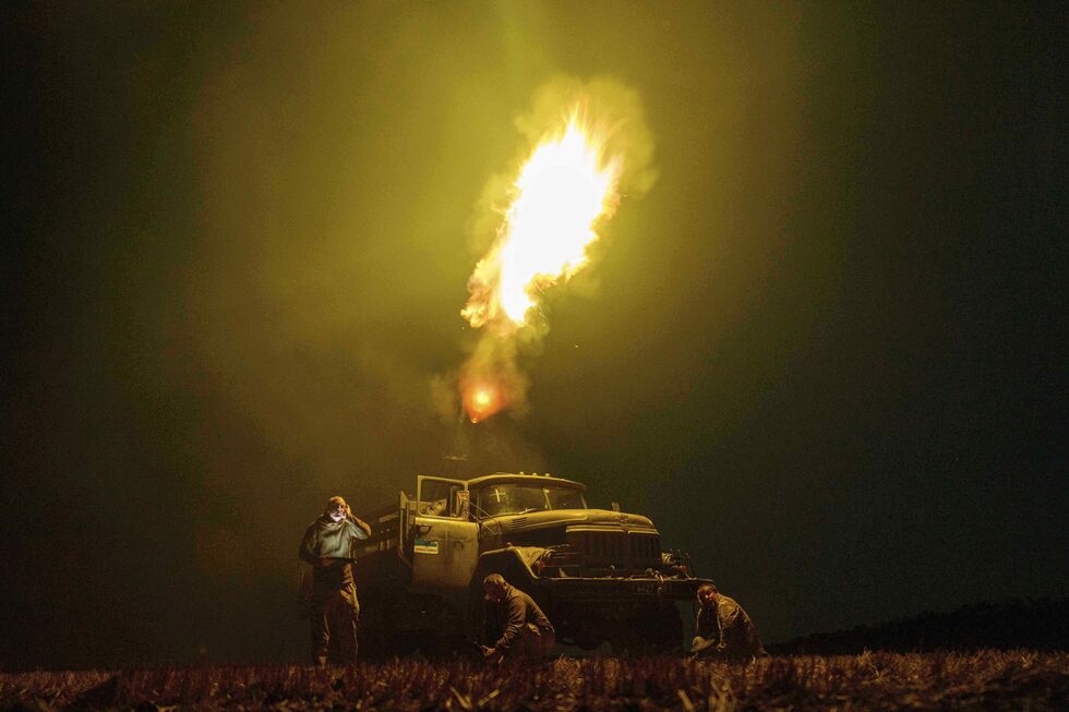 Militares ucranianos perto de camião em noite escura