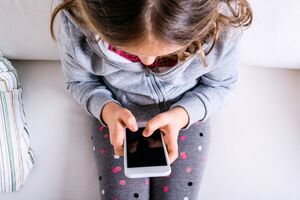 Menina usa telemóvel. Pais espiam filhos com apps e localização