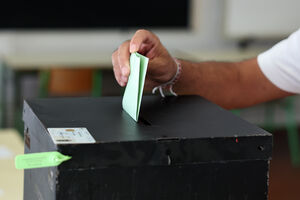 Homem deposita boletim numa urna durante votação