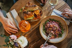 Almoço com sanduíche, salada e bebida entre amigos