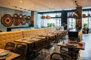 Interior de restaurante com mesas postas e cadeiras de vime