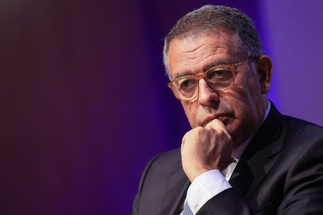 Um homem de fato e óculos, pensativo