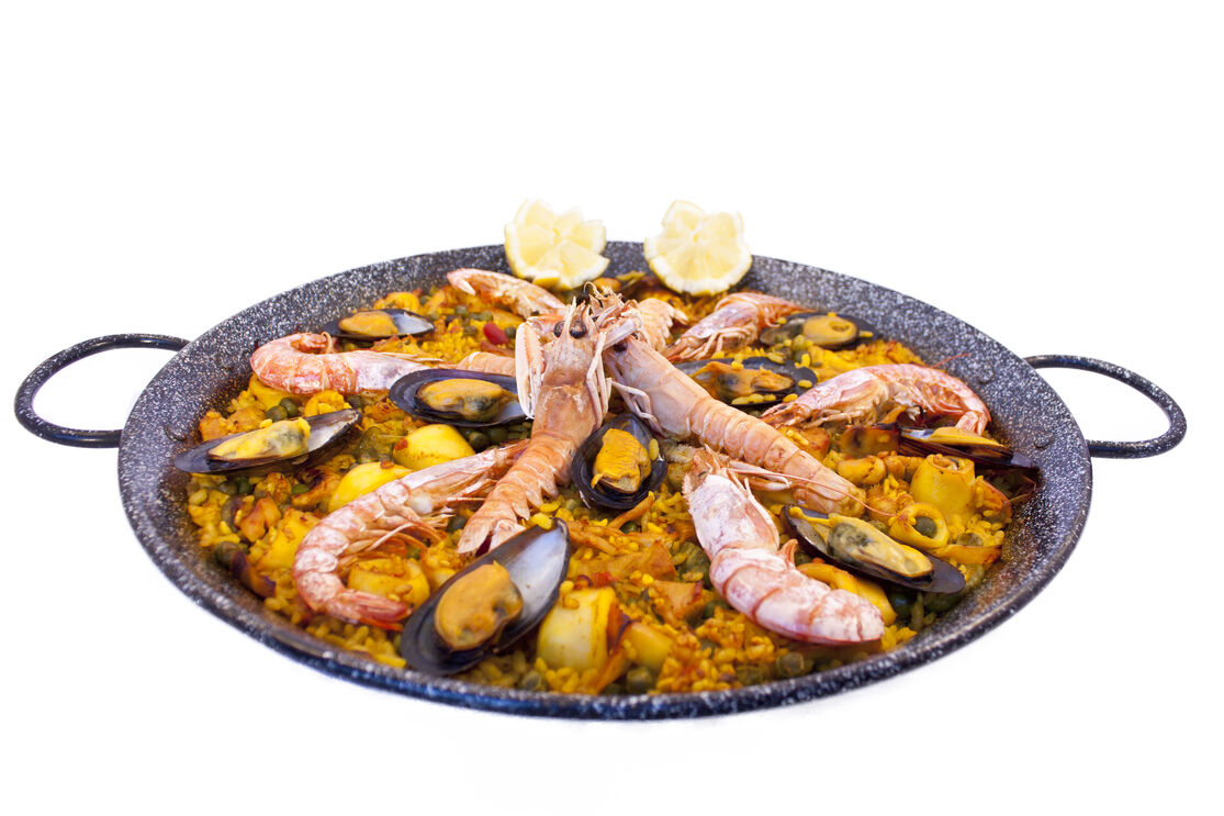 A paella valenciana com marisco, prato tradicional de Espanha apreciado mundialmente