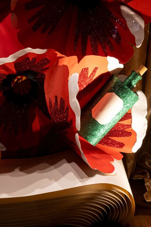 Arranjo floral com garrafa decorativa brilhante sobre livro aberto