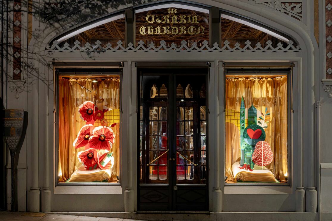 Fachada da Livraria Lello com montras decoradas com livros e ilustrações