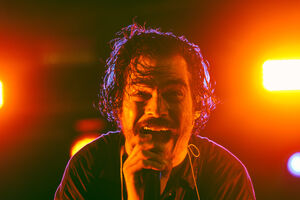 Cantor atua ao vivo num palco iluminado