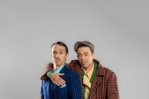 Dois homens posam com vestes clássicas e padrão xadrez