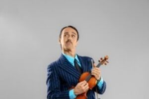 Homem de fato às riscas segura violino e olha para cima