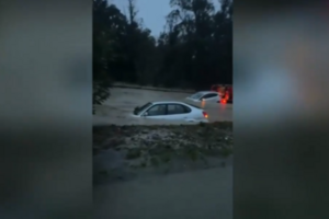 Carros praticamente submersos em estrada alagada em Sesimbra