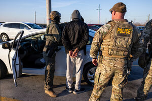 Homem algemado sob custódia de agentes da polícia de imigração nos EUA