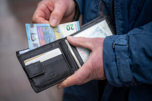 Homem tira dinheiro da carteira