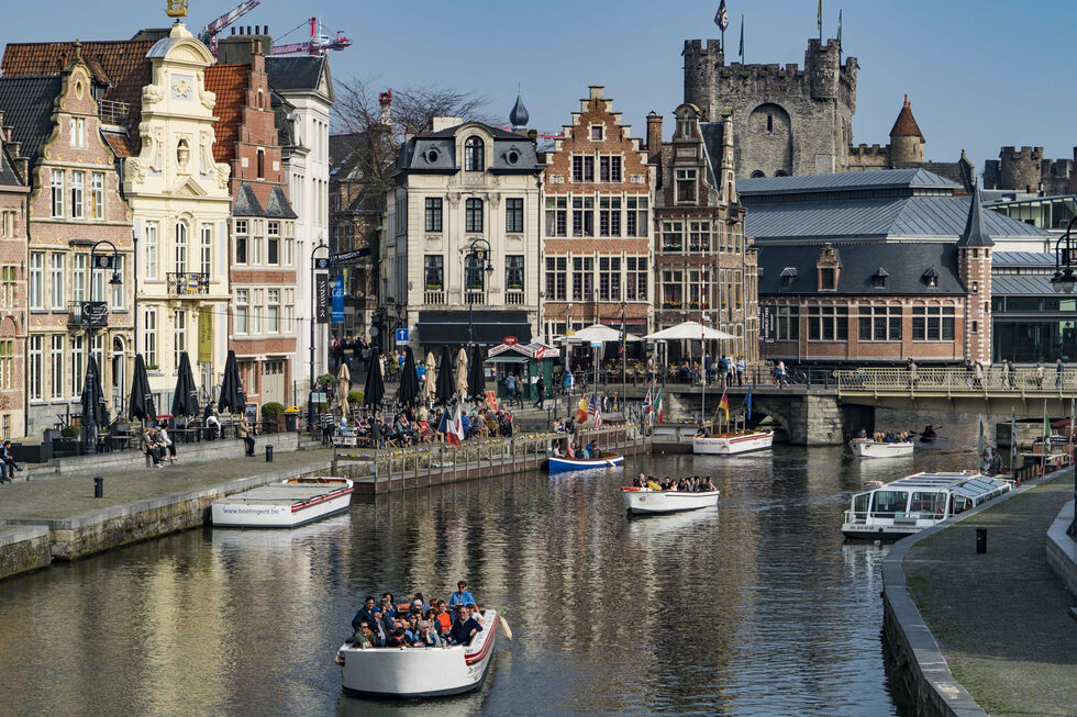 Turistas apreciam um passeio de barco nos canais de Gent, na Bélgica