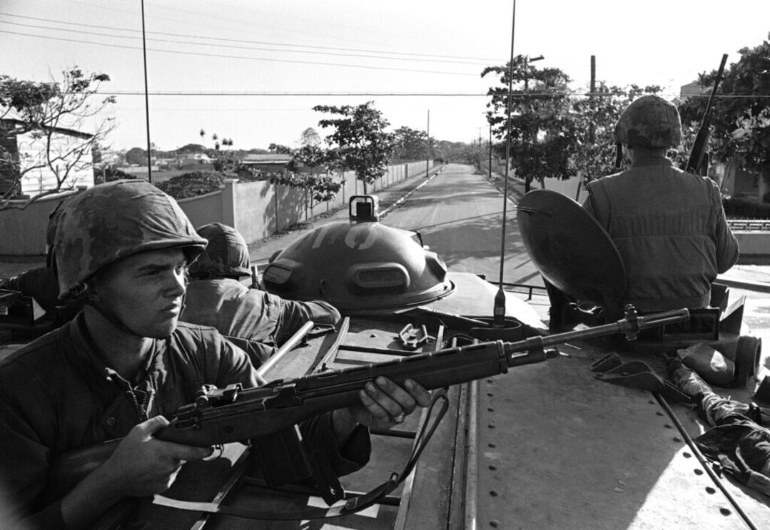 Fuzileiros navais viajam num veículo blindado, percorrendo uma rua de Santo Domingo