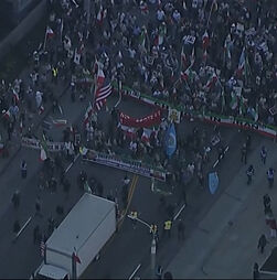 Multidão estende bandeira gigante do Irão durante manifestação em Los Angeles 