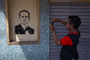 Homem fotografa grafitti de Jacobo Árbenz em Guatemala