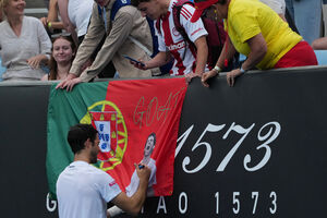 Nuno Borges autografa bandeira de Portugal após vitória no Open da Austrália.
