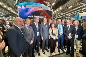 Grupo de pessoas posa junto à estrutura 'Visit Portugal'