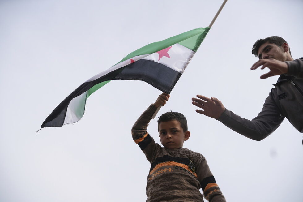 Menino sírio empunha bandeira em Alepo