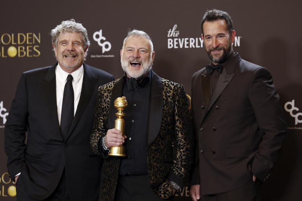 Os produtores John Wells e R. Scott Gemmill com o ator Noah Wyle exibem o troféu ganho por 'The Pitt' 