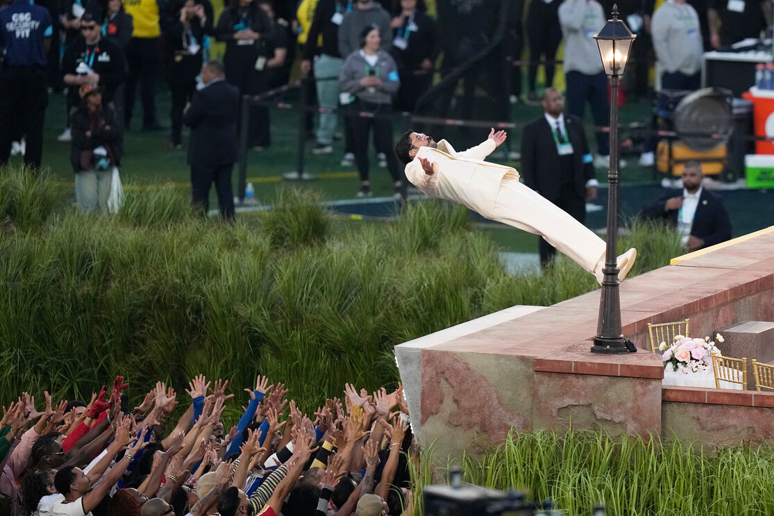 Usher atira-se para a multidão no Super Bowl, com fãs a tentar tocá-lo