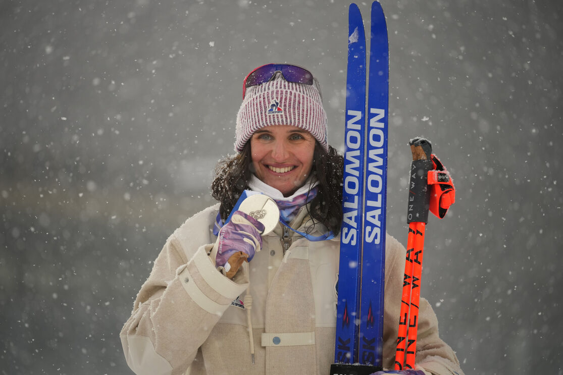 Atleta Julia Simon sorri com medalha nos Jogos Olímpicos de Inverno