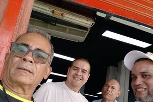 Quatro homens sorriem para a câmara na Venezuela após libertação