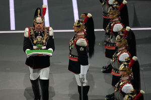 Um guarda Carabinieri carrega a bandeira italiana
