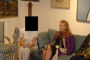 Sarah Ferguson senta-se num sofá enquanto alguém anota num bloco