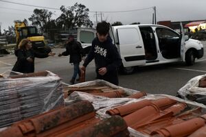 Leonilde Filipe e os netos procuram telhas no estaleiro da freguesia de Maceira 