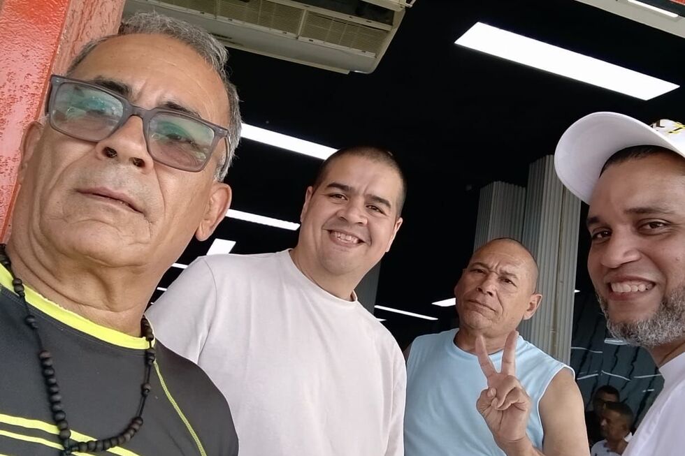 Quatro homens sorriem para a câmara na Venezuela após libertação