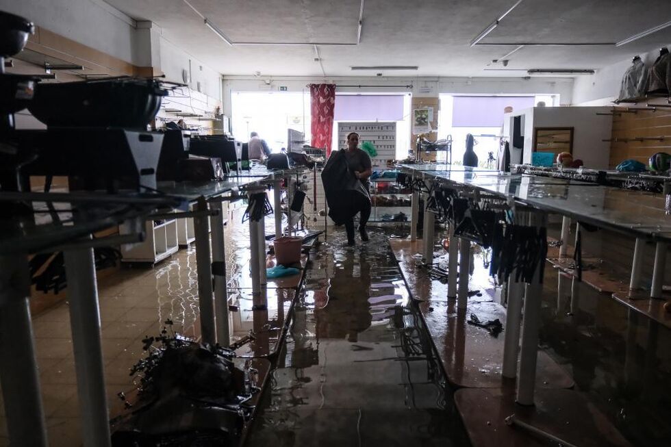 Um comerciante retira do interior da sua loja artigos danificados pela inundação causada pela passagem da depressão Kristin, em Alcácer do Sal
