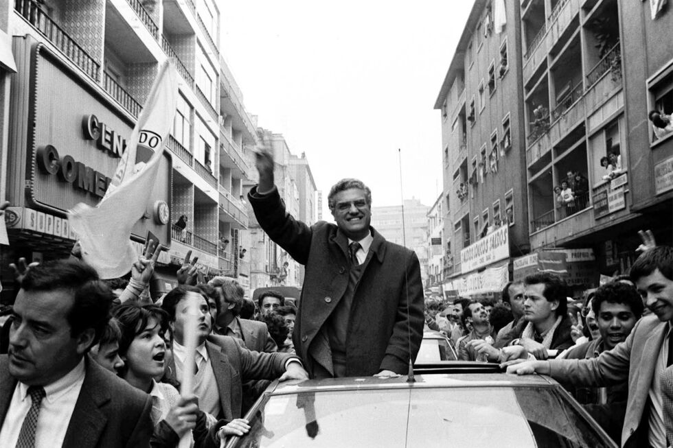 Freitas do Amaral saúda apoiantes em campanha, num carro rodeado por pessoas