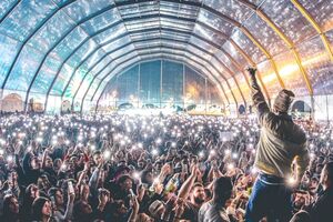 Multidão em concerto filma artista no palco