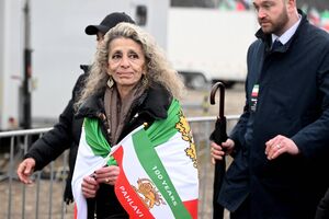 Mulher com bandeira do Irão e referência a Pahlavi, numa homenagem à família real
